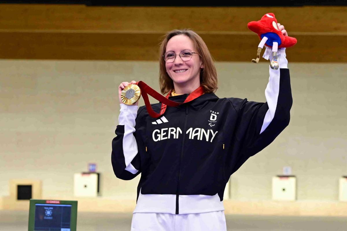 A shooter celebrates her medal